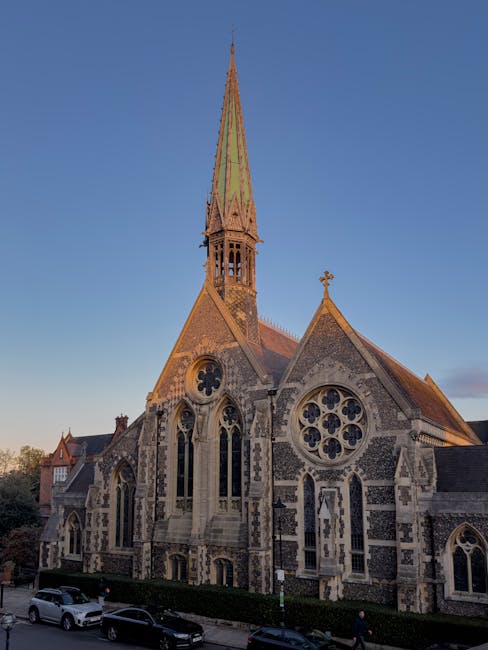 The image features a historic stone church with intricate Gothic-style architecture, including pointed arch windows, decorative tracery, and gargoyle details. The church is topped with a tall, slender